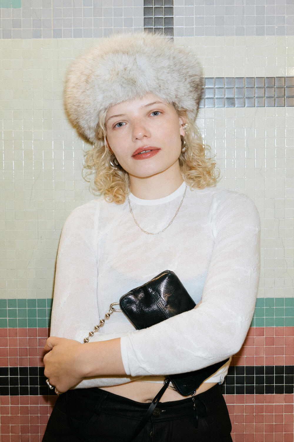 Luisa Gaffron with a more serious look in front of the same tiled wall. The INA KENT bag is still present, this time with a more reserved, almost pensive expression.