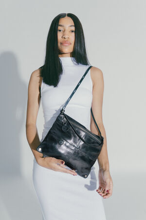 woman wearing a MOONSTRUCK ed.2 over her left shoulder and holding the bag sideways into the camera