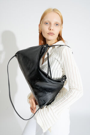 INA KENT DINKUM ed.2 bag in patent ink black is worn as a shoulder bag, the simple style emphasizes its versatility.