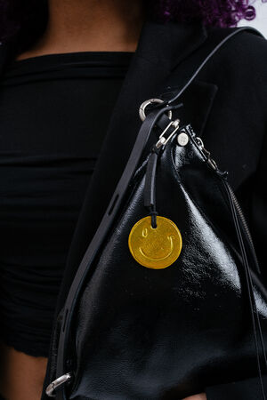 Leder Anhänger in Smiley Form und gelb schimmernder Farbe mit Lederbändchen