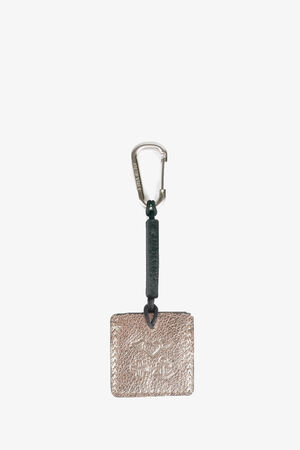 A rectangular metallic INA KENT keychain with embossed design, attached to a dark strap and metal carabiner clip, on a plain white background.