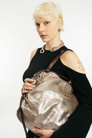 Blondes Model mit goldener metallischen Lederhandtasche