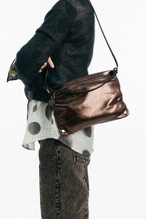 Weiblich gelesenes Model mit braun-glänzender Tasche MOONLIT ed.1 metallic Mocca  auf der Schulter