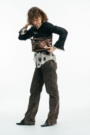 Weiblich gelesenes Model mit braun-glänzender Tasche MOONLIT ed.1 metallic Mocca crossbody