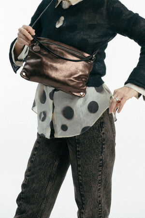 Weiblich gelesenes Model mit braun-glänzender Tasche MOONLIT ed.1 metallic Mocca crossbody