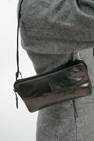 Model mit kleiner silber-grau, glänzenden, kleinen Tasche mit Kugelriemen auf Schulter