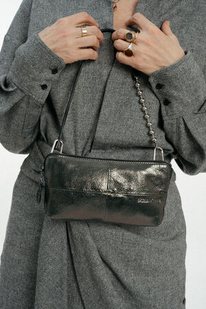 Model mit kleiner silber-grau, glänzenden, kleinen Tasche mit Kugelriemen