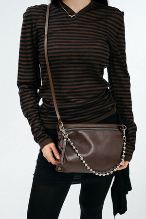 Weiblich gelesenes Model mit brauner Glattledertasche crossbody getragen