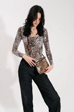 Woman wearing a leopard print long-sleeve top, black pants, and a small metallic INA KENT crossbody bag, standing against a plain white background.