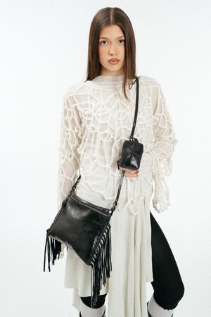 schwarze, metallische Ledertasche mit Fransen, crossbody an einem weiblich gelesen Model getragen