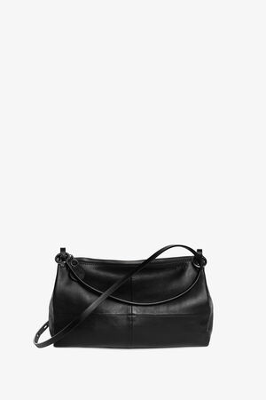 An INA KENT black leather shoulder bag with a zippered top, visible stitching, and an adjustable strap is displayed against a plain white background.