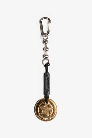 A keychain by INA KENT featuring a metal clip, chain links, a black leather strap, and a round gold-colored sheriff's badge charm labeled "DEPUTY.