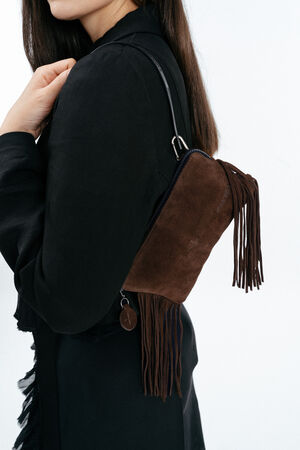 A woman in a black outfit carries an INA KENT brown suede fringe shoulder bag with a zipper and a round keychain accessory.