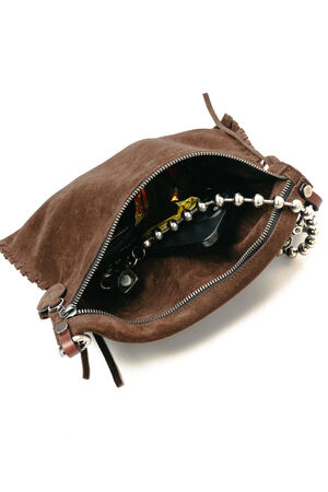 A brown suede zippered pouch by INA KENT is open, revealing a beaded metallic strap, candy, and other small items inside.