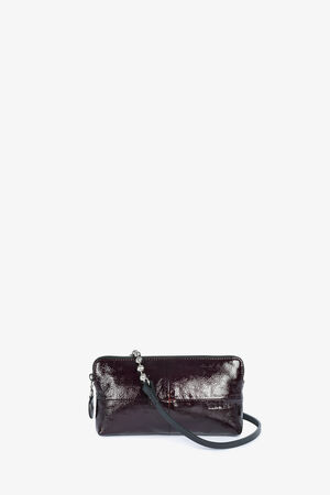 A small, rectangular, dark burgundy leather INA KENT handbag with a shiny finish and a thin black strap, set against a plain white background.