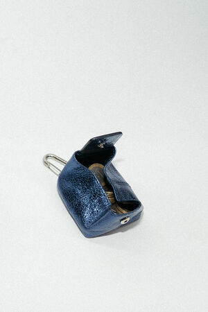 A small, textured blue INA KENT leather coin purse is open, revealing several coins inside, placed on a plain light background.