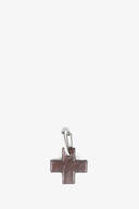 A silver keyring featuring a dark brown leather cross-shaped pendant by INA KENT, displayed against a plain white background.