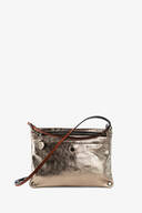 A metallic gold leather INA KENT crossbody bag with a front zipper pocket, small round pendant, and a black and brown adjustable strap.