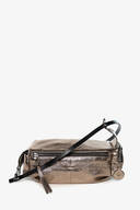 A metallic bronze INA KENT crossbody bag with a black adjustable strap, zip closure, and decorative round charm, displayed against a white background.